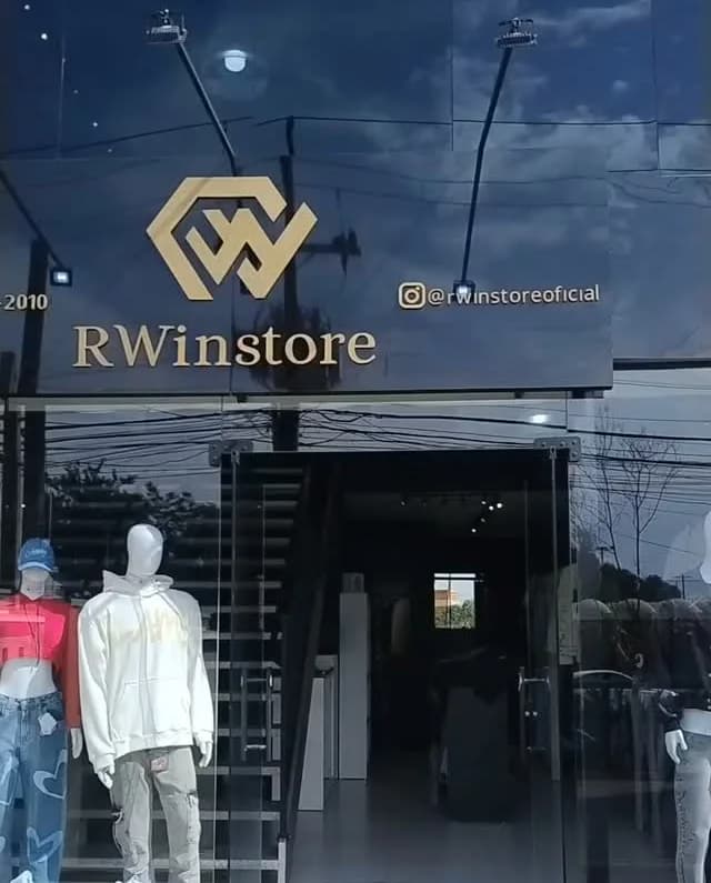 A fachada da RWinstore: vidro escuro com o W dourado, manequins de moletom e jeans na vitrine